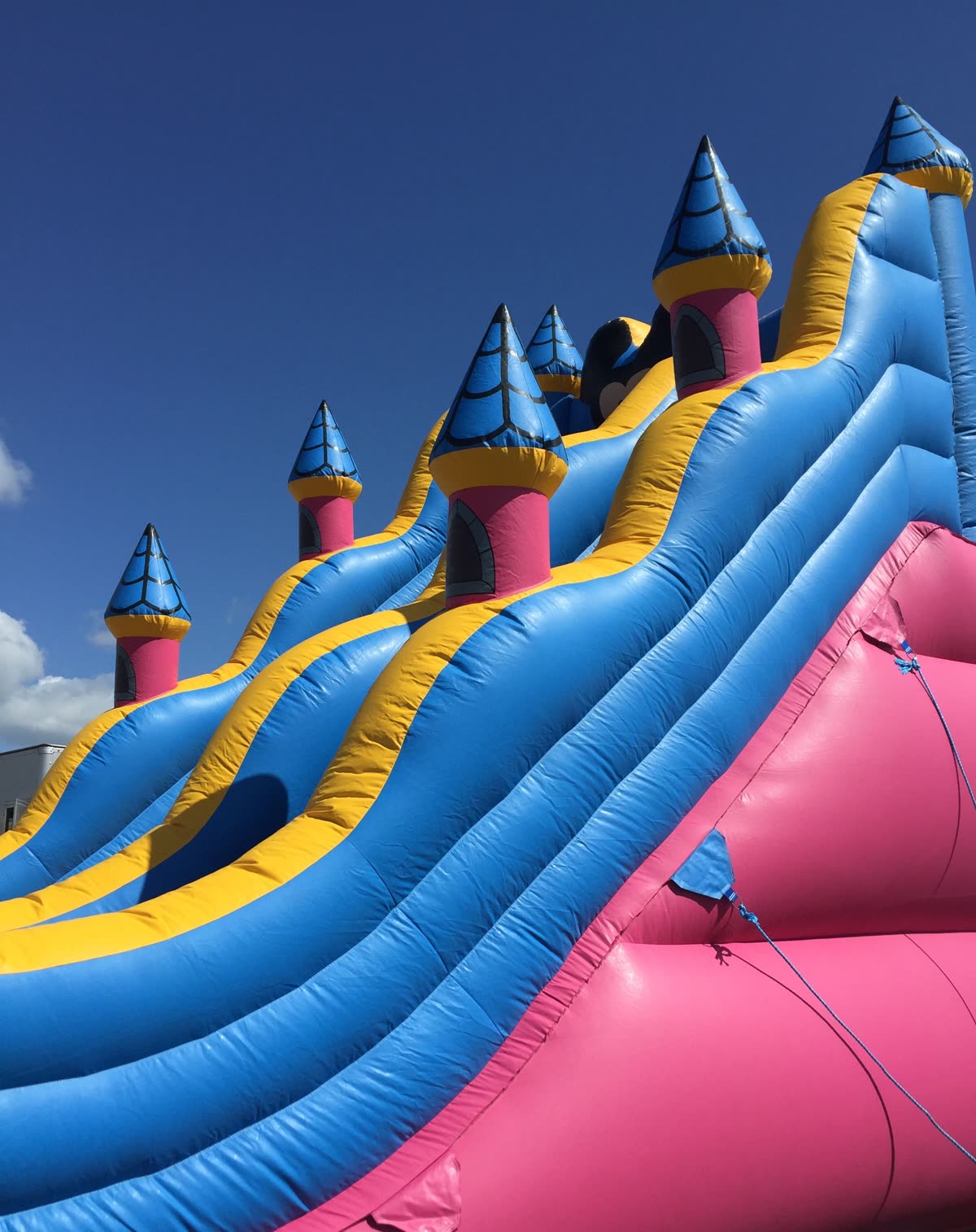 Children enjoying colourful inflatable slides and games